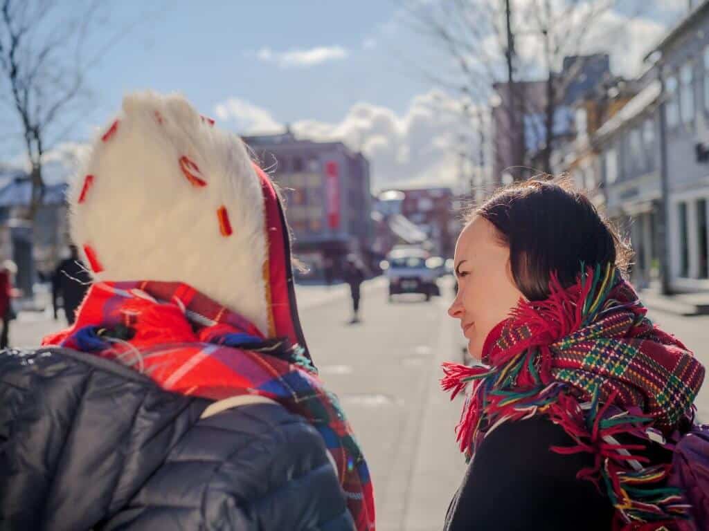 Bildet viser to samiske kvinner som snakker med hverandre i Storgata i Tromsø